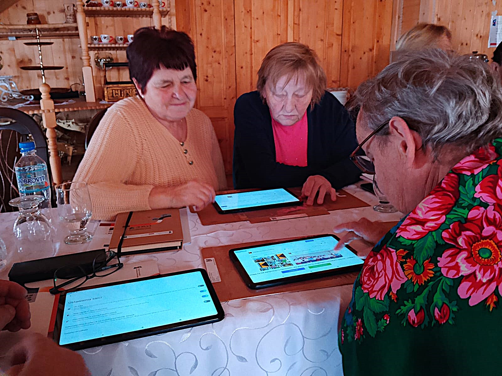 zdjecie przedstawia osoby siedzace przy stole sali szkoleniowej i uczestniczące w szkoleniu